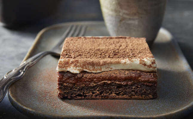 Brownie tiramisu on grey plate with fork and cup.