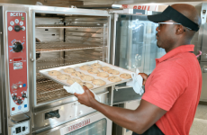 Operator placing cookies into an oven