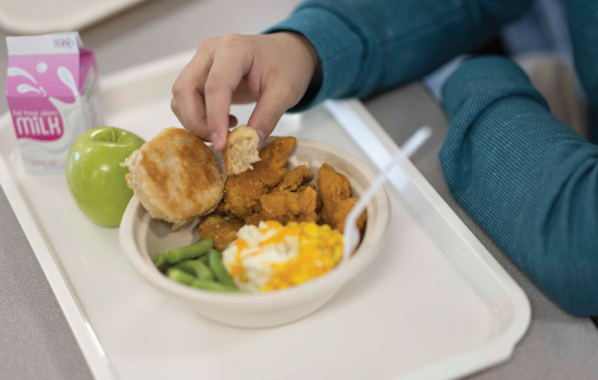 A student eating a biscuit at lunch