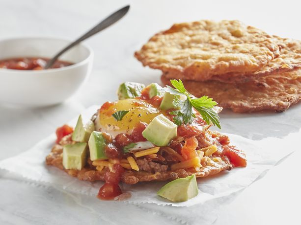 Garlic cheddar biscuit tostadas shown with assorted toppings and a side of salsa in a white bowl